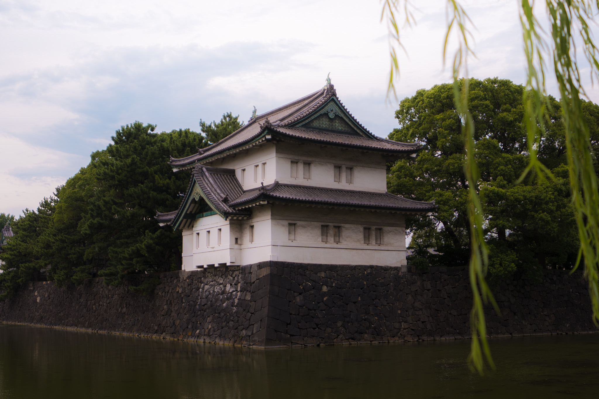 Historic Tokyo temple building beside water and trees